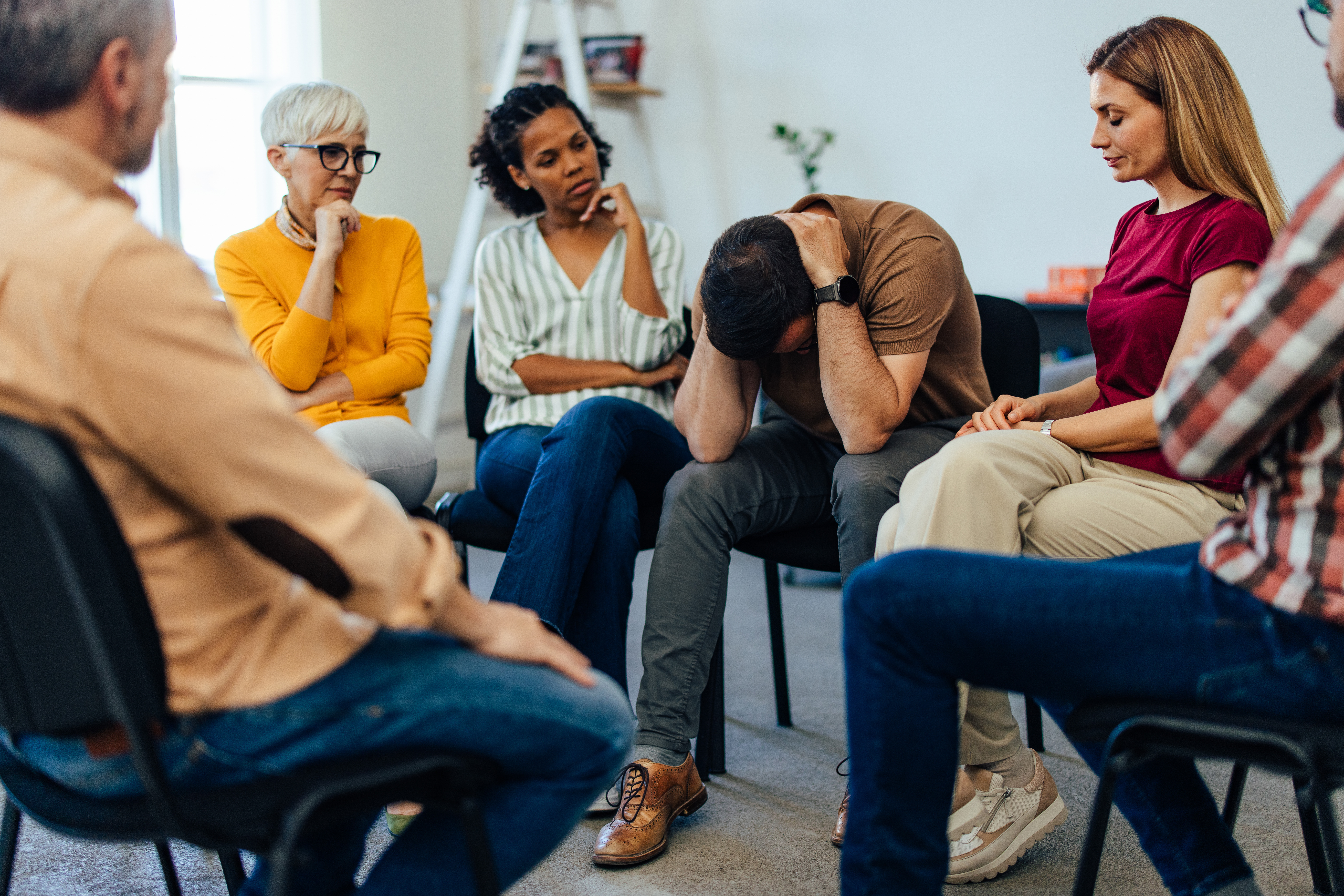 A support group sitting in a circle during a group session